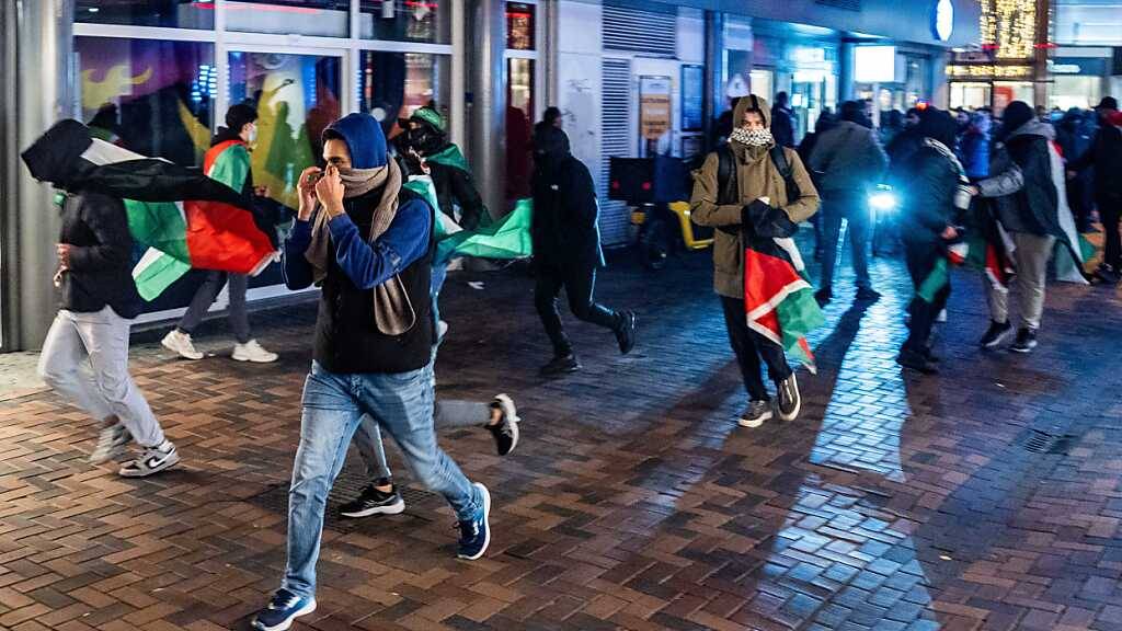 Menschen demonstrieren mit propalästinensischen Fahnen während des Spiels Ajax - Maccabi Tel-Aviv in Amsterdam. Foto: Jeroen Jumelet/ANP/dpa