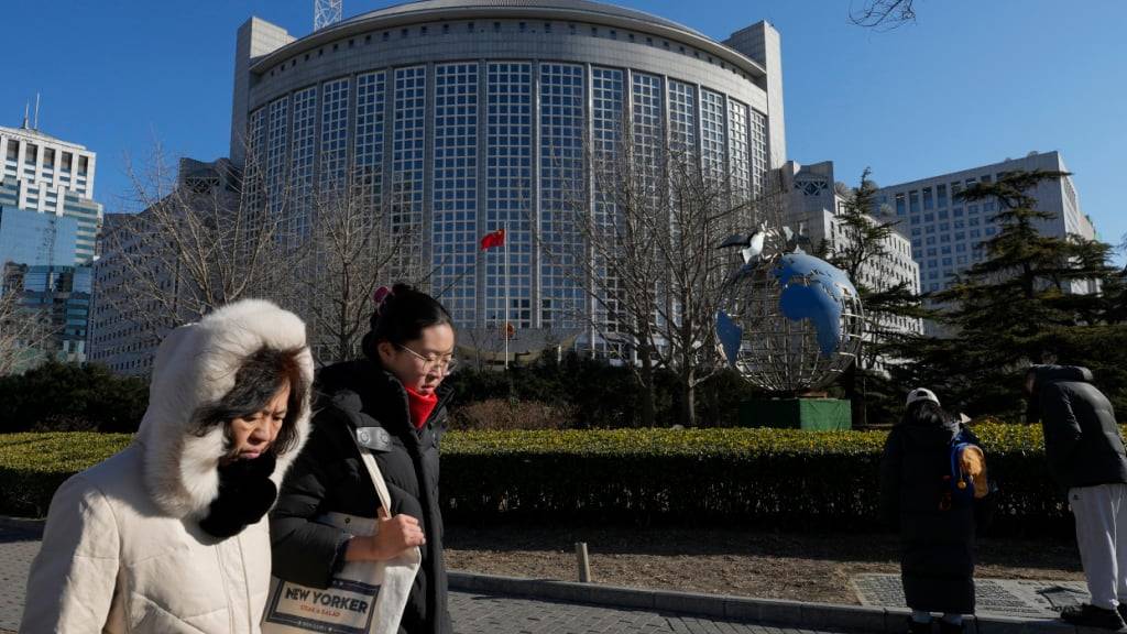 ARCHIV - Menschen gehen am chinesischen Außenministerium vorbei. Foto: Andy Wong/AP/dpa