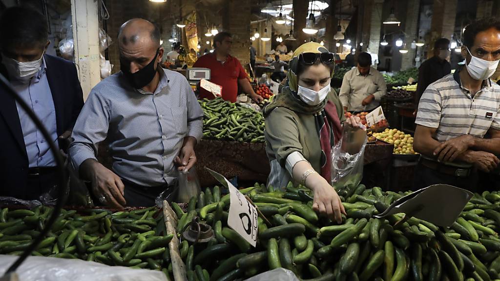 Kunden mit Schutzmasken kaufen Gemüse auf dem Basar von Zandschan ein. Wegen des dramatischen Anstiegs der Anzahl der täglichen Corona-Toten und Neuinfektionen hat Präsident Ruhani eine Maskenpflicht in Behörden, im öffentlichen Nahverkehr sowie auf überdachten Flächen von Einkaufszentren angeordnet.