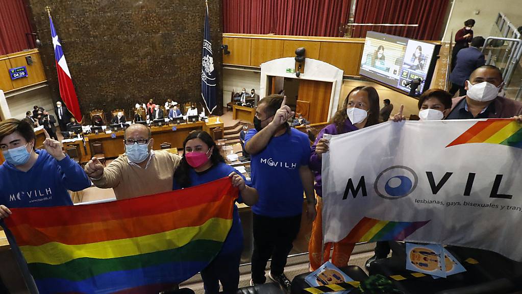 Mitglieder zweier NGOs feiern im Senat in ValparaÌso die Entscheidung f ̧r die gleichgeschlechtliche Ehe. Nach jahrelangem Ringen hat Chile Eheschlieflungen von Menschen des gleichen Geschlechts erlaubt. Foto: Leonardo Rubilar/Agencia Uno/dpa