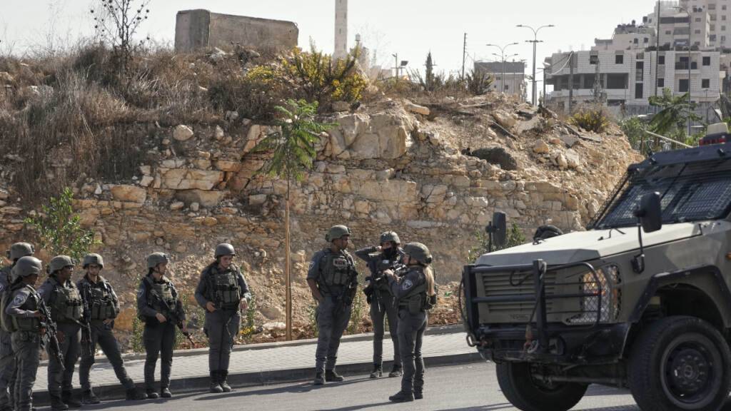 Israelische Soldaten versammeln sich am Ort eines Schussangriffs, den palästinensische Bewaffnete an einer Kreuzung in der Nähe von Hebron im besetzten Westjordanland verübt haben. Foto: Mahmoud Illean/AP/dpa