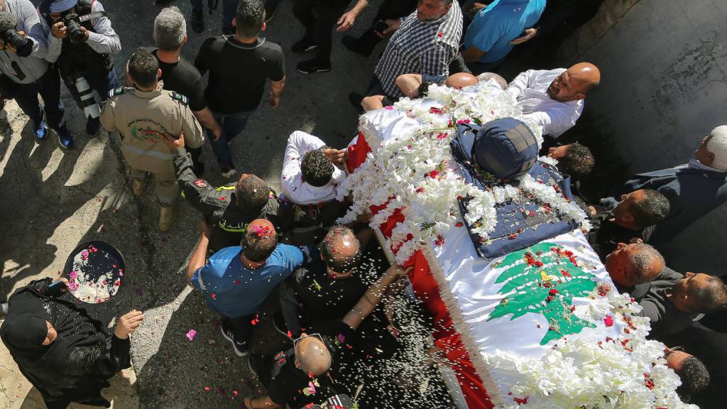 ARCHIV - Eine Frau wirft Reis und Rosenblätter auf den Sarg der libanesischen Journalistin Amal Khalil, die am Mittwoch bei einem israelischen Luftangriff getötet wurde, während ihres Trauerzuges in dem südlibanesischen Dorf Baysariyeh. Foto: Marwan Naamani/dpa