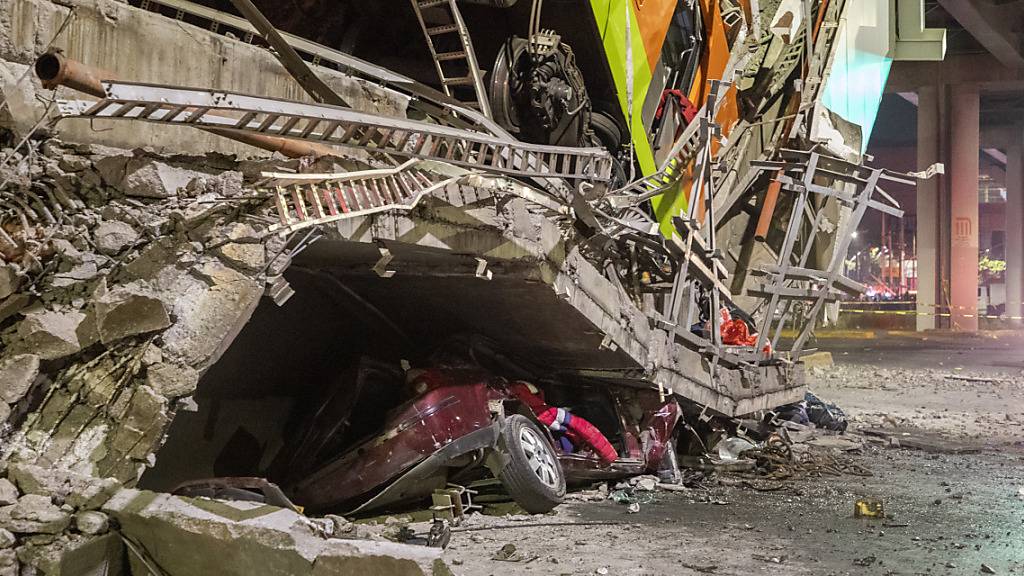 Ein Auto liegt unter Trümmern, nachdem ein Brückenabschnitt der U-Bahn-Linie 12 in Mexiko-Stadt zusammengebrochen war. Zwei Waggons stürzen auf eine viel befahrene Strasse.