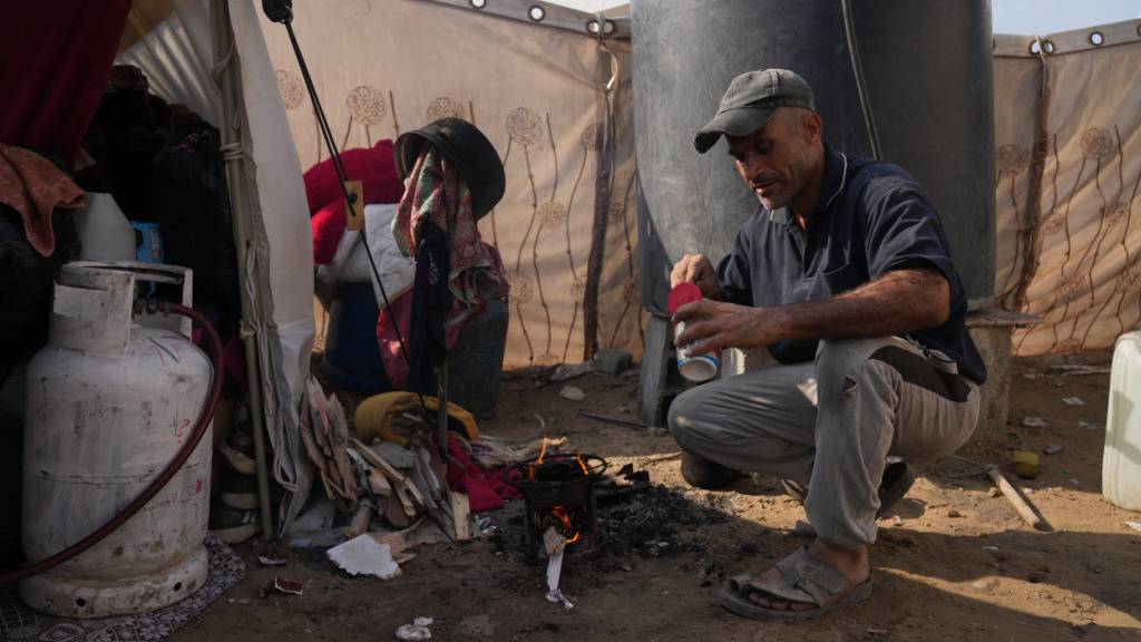 dpatopbilder - Kamal al-Yaziji (50) bereitet Tee vor seinem Zelt zu, in dem er und seine Familie leben, nachdem ihr Haus im Krieg zwischen Israel und der Hamas zerstört wurde. Foto: Abdel Kareem Hana/AP/dpa