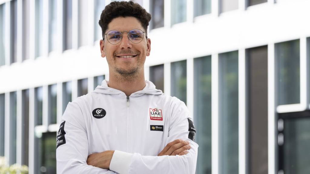 Joao Almeida lächelt zu Beginn der Tour de Romandie in Weiss in die Kamera. Nun darf er das Gelbe Trikot mit nach Hause nehmen
