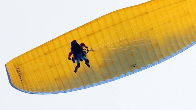 Gleitschirmflieger landet auf dem Rücken