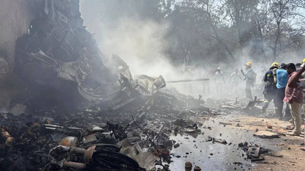 Menschen stehen um die Trümmer eines abgestürzten Flugzeugs in der nordwestindischen Stadt Ahmedabad im Bundesstaat Gujarat. Foto: Ajit Solanki/AP/dpa