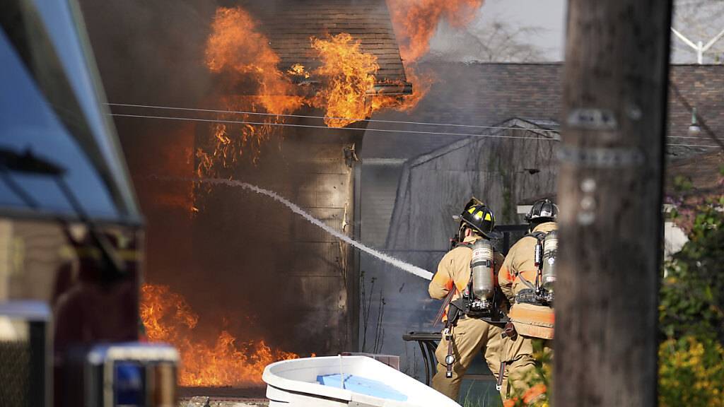 dpatopbilder - Feuerwehrleute bekämpfen einen Hausbrand im US-Bundesstaat New Jersey. Wegen eines sich schnell ausbreitenden Waldbrandes sind Tausende Menschen aus ihren Häusern geflohen. Foto: Matt Slocum/AP/dpa