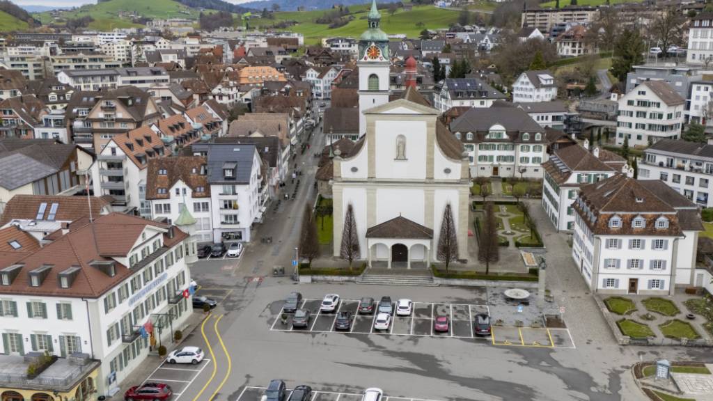 Der Seeplatz mit dem Parkplatz und der Katholischen Kirche St. Peter und Paul im Dorfzentrum von Küssnacht SZ.
