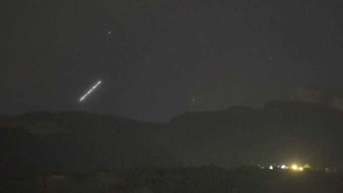 Lichterkette schwebt am Himmel über den Schweizer Alpen