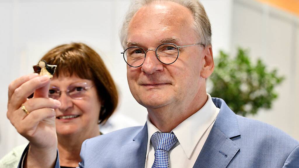 Sachsen-Anhalts amtierender Ministerpräsident Reiner Haseloff (CDU) zeigt einen Glücksbringer. Nach ersten Prognosen zeichnet sich ein klarer Sieg der regierenden Christdemokraten ab. Die Wahl gilt als wichtiger Stimmungstest vor der Bundestagswahl im September. Foto: Frank May/dpa-Zentralbild/dpa