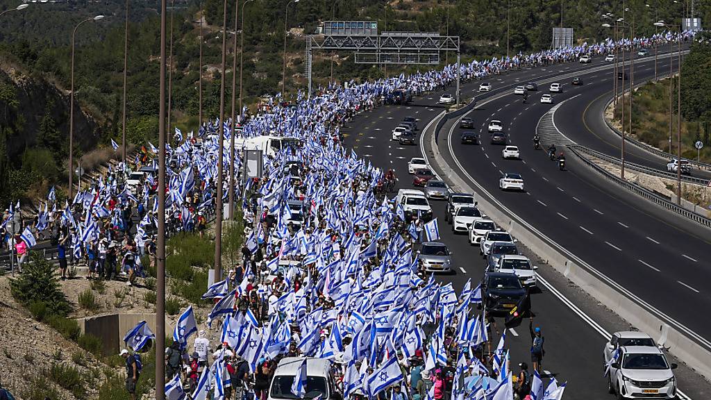 dpatopbilder - Tausende Israelis marschieren auf einer Autobahn in Richtung Jerusalem, um gegen die Pläne der Regierung von Premierminister Netanjahu zu protestieren, das Justizsystem zu reformieren. Foto: Ohad Zwigenberg/AP/dpa