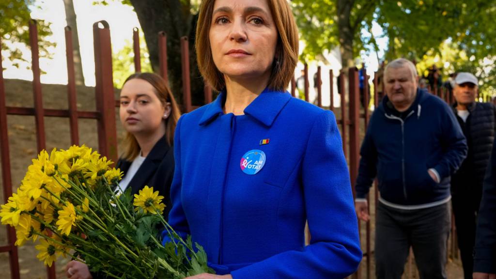 Moldaus Präsidentin Maia Sandu verlässt ein Wahllokal und hält dabei einen Blumenstrauß, nachdem sie bei der Parlamentswahl ihre Stimme abgegeben hat. Foto: Vadim Ghirda/AP/dpa