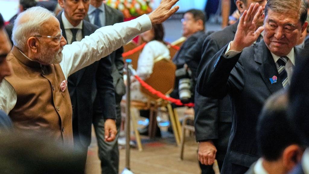 Der indische Premierminister Narendra Modi (l) und der japanische Premierminister Shigeru Ishiba (r) winken beim Verlassen des Japanisch-Indischen Wirtschaftsforums. Foto: Eugene Hoshiko/AP/dpa