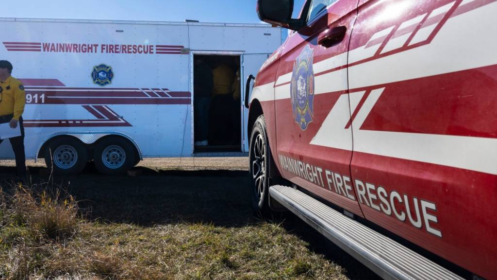 Feuerwehrleute sind im Brandgebiet auf dem CFB Wainwright südlich der Stadt Wainwright in Alberta, Kanada, im Einsatz. Bei einem Brand auf dem Militärstützpunkt Wainwright in Kanada sind nach Angaben von Premierminister Carney vier Menschen gestorben. Dutzende hätten schwere Verletzungen erlitten, sagte Carney. Foto: John Ulan/The Canadian Press/AP/dpa