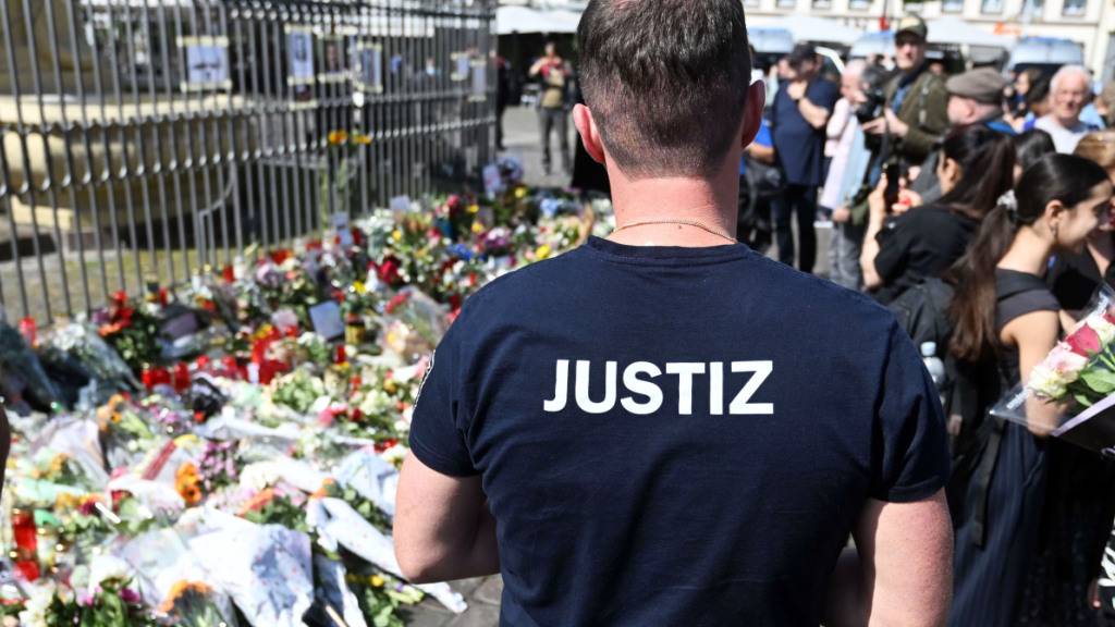 Nach dem Tod eines Polizisten, der nach einer Messerattacke mit mehreren Verletzten gestorben ist, liegen am Marktplatz in der unmittelbaren Nähe des Tatorts Blumen und Kerzen. Foto: Uli Deck/dpa