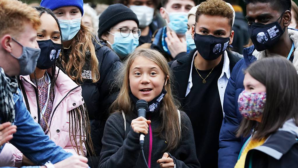 Klimaaktivistin Greta Thunberg (M) spricht in ein Mikrofon, während sie zusammen mit anderen Aktivisten an einer Demonstration am Rande des UN-Klimagipfels COP26 in Glasgow teilnimmt. Foto: Andrew Milligan/PA Wire/dpa