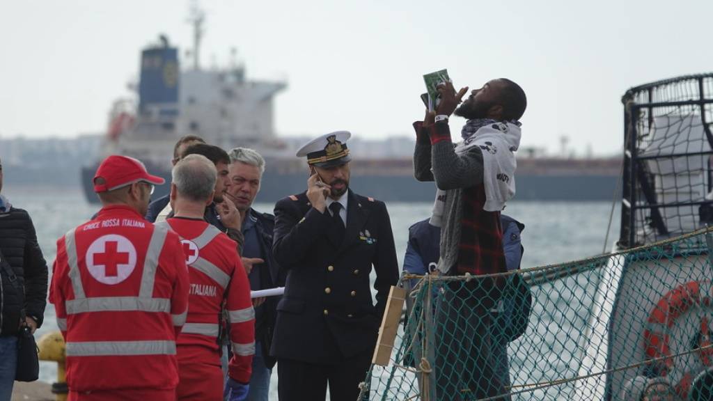 Ein Flüchtling freut sich über die sichere Ankunft in einem italienischen Hafen.