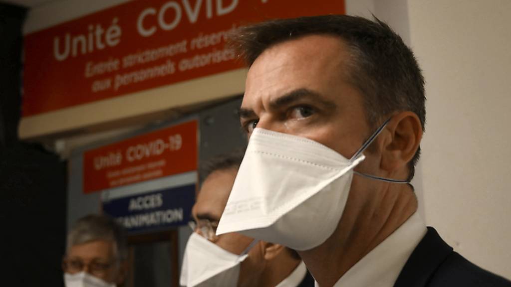 Olivier Veran, Gesundheitsminister von Frankreich, spricht mit medizinischen Mitarbeitern während eines Besuchs eines öffentlichen Krankenhauses. Foto: Christophe Simon/POOL AFP/AP/dpa