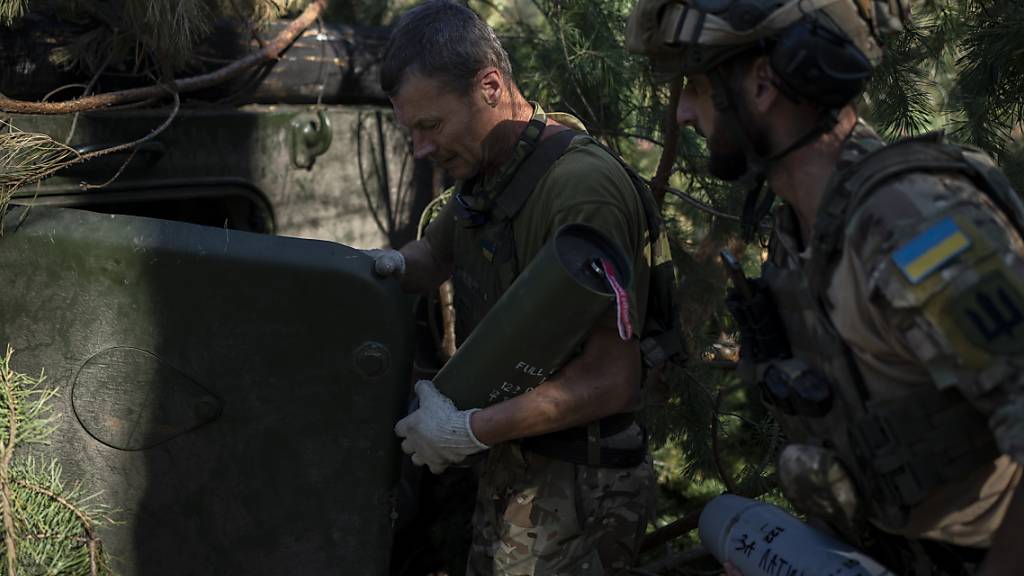 Ukrainische Soldaten laden an der Frontlinie bei Lyman eine Haubitze mit einer Granate. Foto: Bram Janssen/AP/dpa