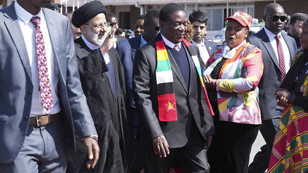 Simbabwes Präsident Emmerson Mnangagwa (M) empfängt Irans Präsidenten Ebrahim Raisi (2.v.l) nach dessen Ankunft in Harare. Foto: Tsvangirayi Mukwazhi/AP/dpa