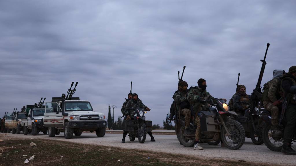 Ein Konvoi der syrischen Regierungstruppen fährt auf einer Straße, die in die Stadt führt. Die syrische Armee hat nach eigenen Angaben die Kontrolle über wichtige Orte nahe der nordsyrischen Stadt Aleppo von kurdischen Kräften übernommen. Foto: Ghaith Alsayed/AP/dpa