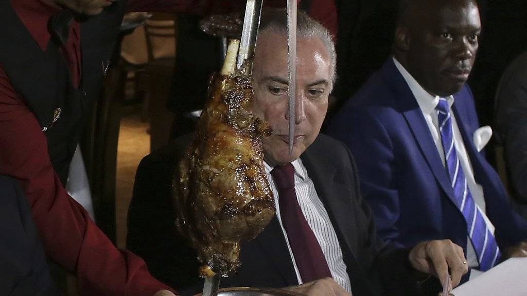 Krisenkommunikation geht durch den Magen: Brasiliens Präsident Michel Temer neben dem Botschafter Angolas in einem Steakhouse.