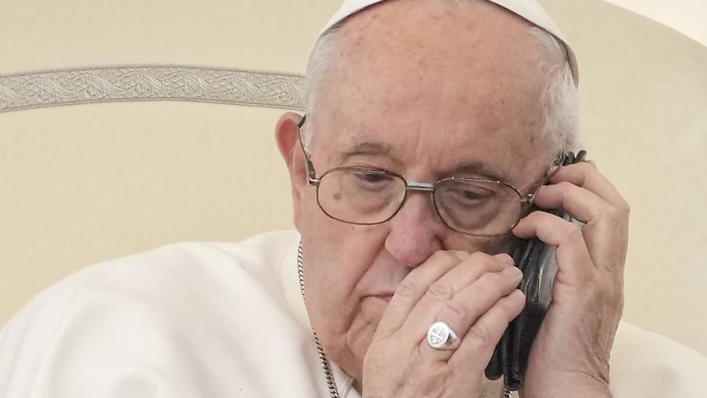 Papst Franziskus telefoniert während seiner wöchentlichen Generalaudienz auf dem Petersplatz im Vatikan. Foto: Andrew Medichini/AP/dpa