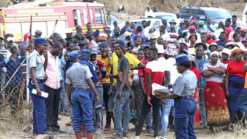Angehörige und Mitarbeitende stehen am Tor der Bay Horse Mine, nachdem ein Schacht eingestürzt war.
