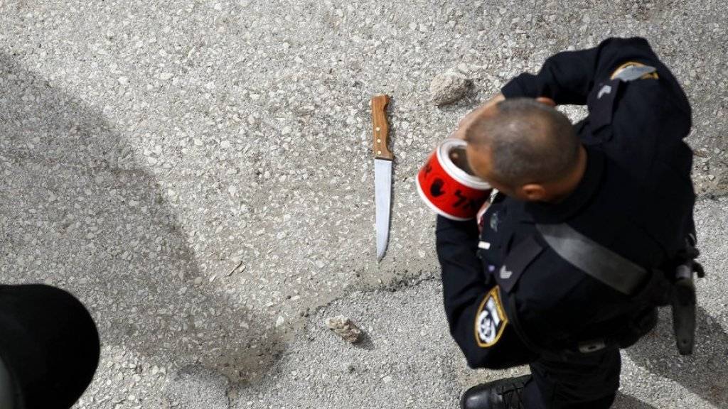 Ein israelische Polizist sichert den Tatort nach einer Messerattacke eines Palästinensers in Hebron. Die Zahl politisch motivierter Attacken auf Israelis hat in den vergangenen Monaten stark zugenommen.