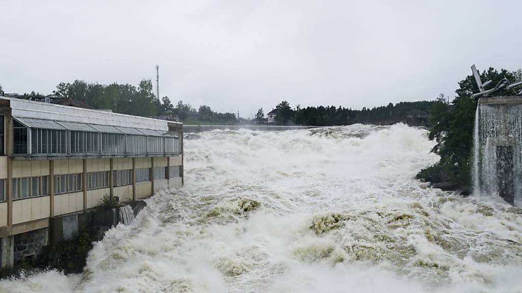 Der Fluss Storelva überschwemmt das Hoenefoss Center. Die extremwetterbedingten Überschwemmungen im Süden von Norwegen haben zu zahlreichen Erdrutschen und zur Evakuierung von Hunderten Menschen geführt. Foto: Annika Byrde/NTB Scanpix/AP/dpa