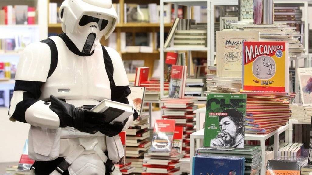 Ein Stormtrooper nimmt auf der Buchmesse in Guadalajara ein «Star Wars»-Buch in Augenschein.