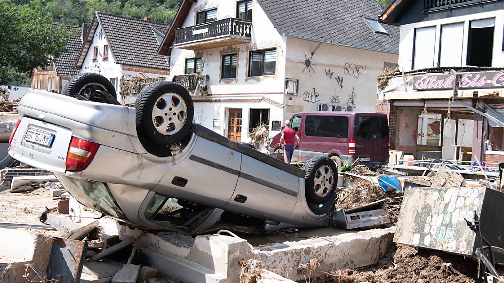 Ein von der Flut mitgerissenes Auto liegt in der Stadtmitte von Altenahr in Rheinland-Pfalz. Foto: Boris Roessler/dpa