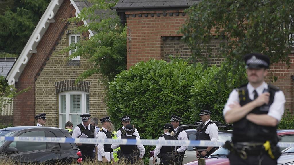 ARCHIV - Polizeibeamte errichten eine Absperrung, nachdem ein Auto in ein Grundschulgebäude in Wimbledon gekracht ist. Foto: Kin Cheung/AP