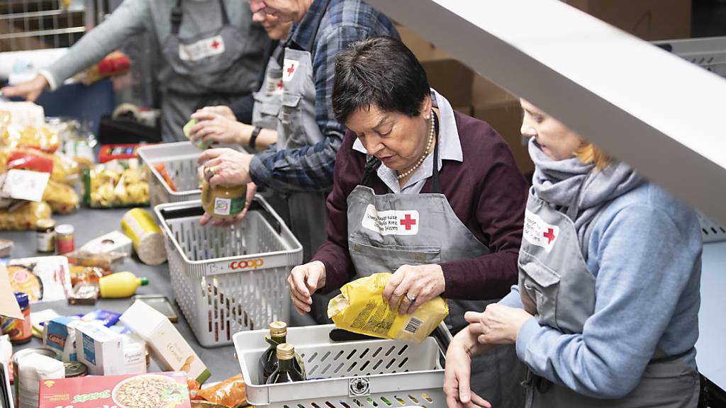 Freiwillige Helfer des Schweizerischen Roten Kreuzes kontrollieren und sortieren den Inhalt von gespendeten Paketen der Spendenaktion «2x Weihnachten». (Archivbild)