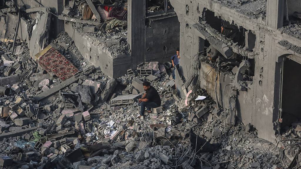 Menschen durchsuchen Gebäude, die bei israelischen Luftangriffen im Gaza-Streifen in Chan Junis zerstört wurden. Foto: Mohammed Talatene/dpa