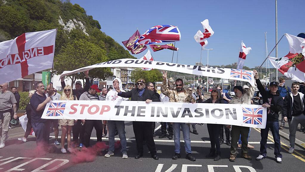 Demonstranten nehmen mit Fahnen und einem Banner mit der Aufschrift «Stop the Invasion» (Stoppt die Invasion) an einem Protest gegen Flüchtlinge, die über den Ärmelkanal nach Kent kommen, teil.