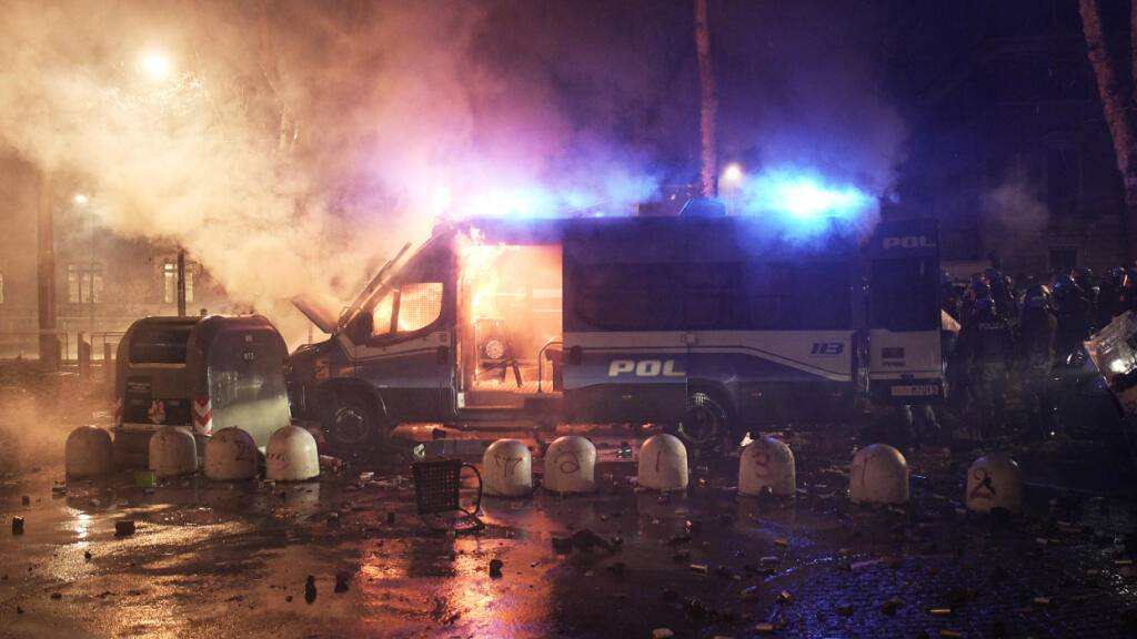 Ein Polizeifahrzeug brennt bei Ausschreitungen nach einer Demonstration gegen die Räumung des linken Zentrums Askatasuna. Das Jugendzentrum war Ende Dezember geräumt worden. Foto: Marco Alpozzi/LaPresse via ZUMA Press/dpa