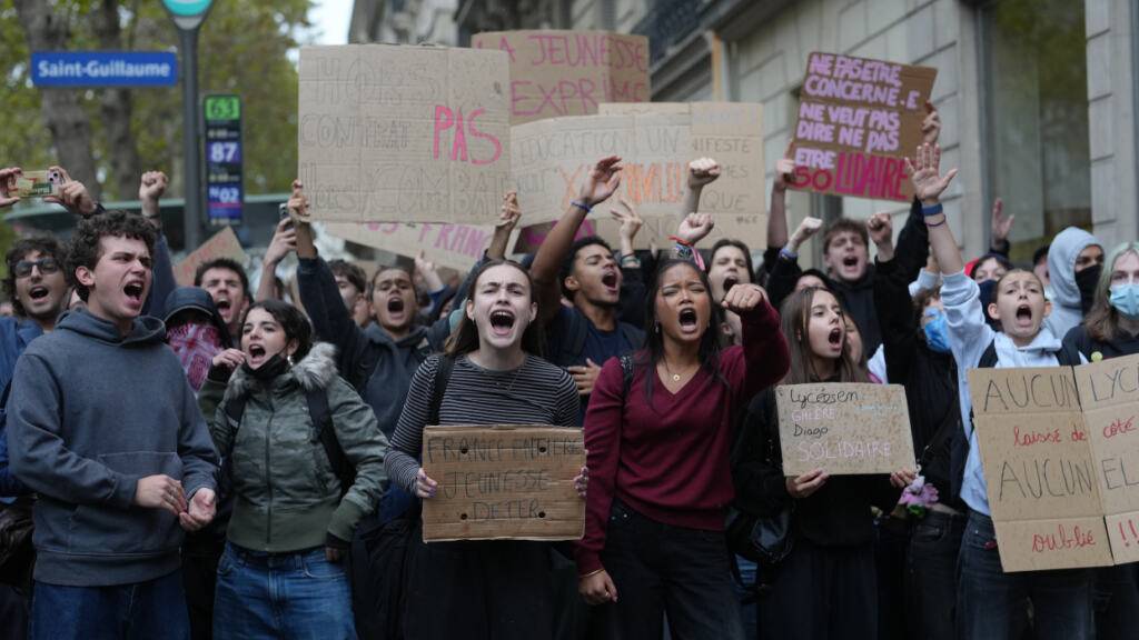 Schüler skandieren vor einem blockierten Gymnasium Parolen, um gegen die mangelnde Ausstattung der Schulen zu protestieren. Foto: Thibault Camus/AP/dpa
