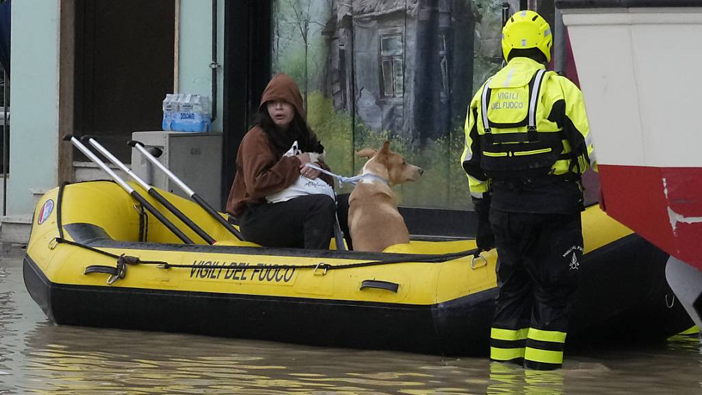 dpatopbilder - Feuerwehrleute retten eine Anwohnerin und ihren Hund. Nach den schweren Unwettern mit heftigen Regenfällen in der mittelitalienischen Region Toskana ist die Zahl der Todesopfer gestiegen. Foto: Gregorio Borgia/AP/dpa