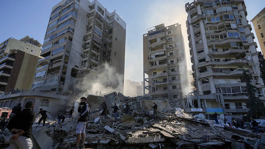 Anwohner durchsuchen nach einem israelischen Luftangriff ein eingestürztes Gebäude im Stadtviertel Tajuna. Foto: Hassan Ammar/AP