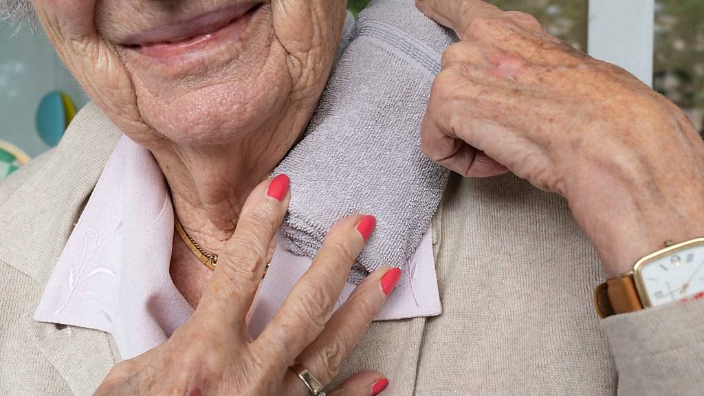 Eine ältere Frau kühlt sich wegen der Hitze den Nacken. (Archivaufname)