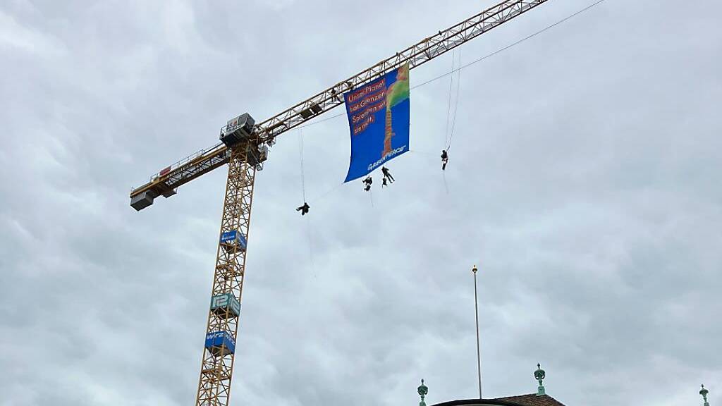 Greenpeace-Aktivisten seilen sich von Kran beim Bundesplatz ab