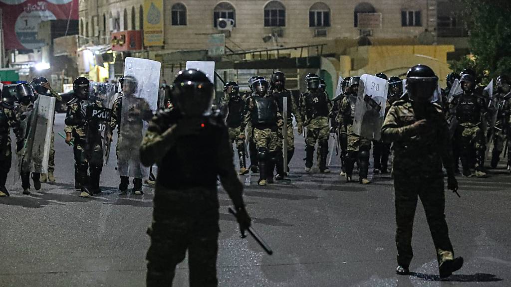 Polizisten versuchen während eines Protests in Basra Demonstranten daran zu verhindern, ein Regionalbüro des Parlaments zu stürmen. Foto: Nabil Al-Jurani/AP/dpa