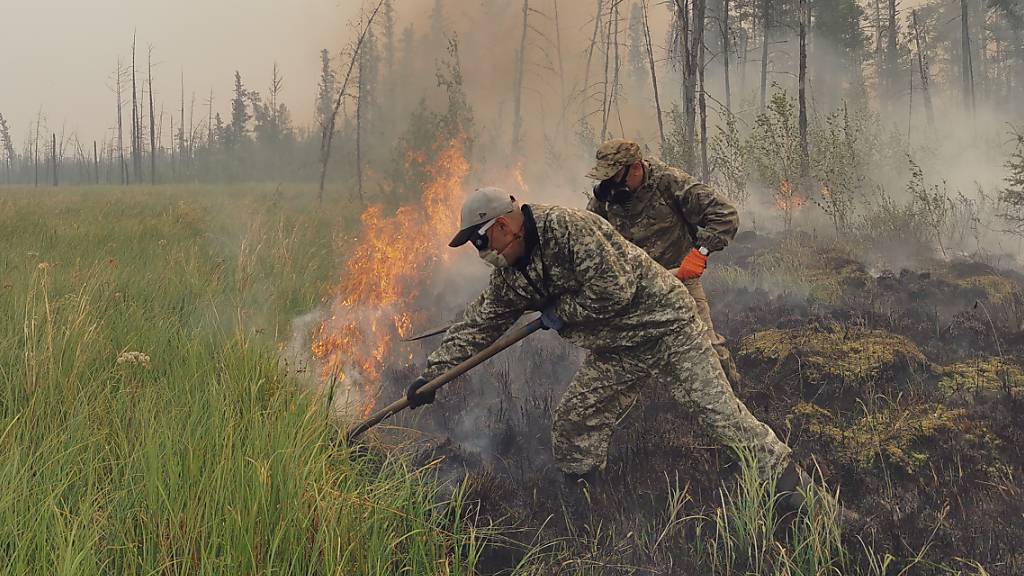 Freiwillige löschen einen Waldbrand in der Republik Sacha, auch bekannt als Jakutien, im Fernen Osten Russlands, Samstag, 17. Juli 2021. Foto: Ivan Nikiforov/AP/dpa