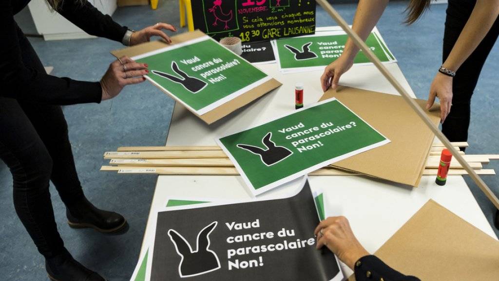 Mitarbeiterinnen einer Kindertagesstätte bereiten Plakate für die Kundgebung in Lausanne vor.