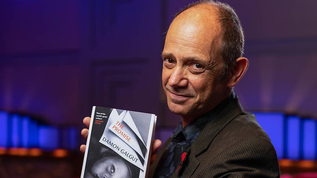 Damon Galgut, Schriftsteller aus Südafrika, hält bei der Verleihung des Booker Prize sein Buch «The Promise» hoch. Foto: David Parry/PA Wire/dpa - ACHTUNG: Nur zur redaktionellen Verwendung und nur mit vollständiger Nennung des vorstehenden Credits