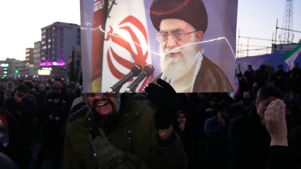 Anhänger der Regierung trauern in einer Versammlung in Teheran, Iran, nachdem das staatliche Fernsehen offiziell den Tod des iranischen Obersten Führers Ajatollah Ali Chamenei (auf dem Plakat) bekannt gegeben hat. Foto: Vahid Salemi/AP/dpa