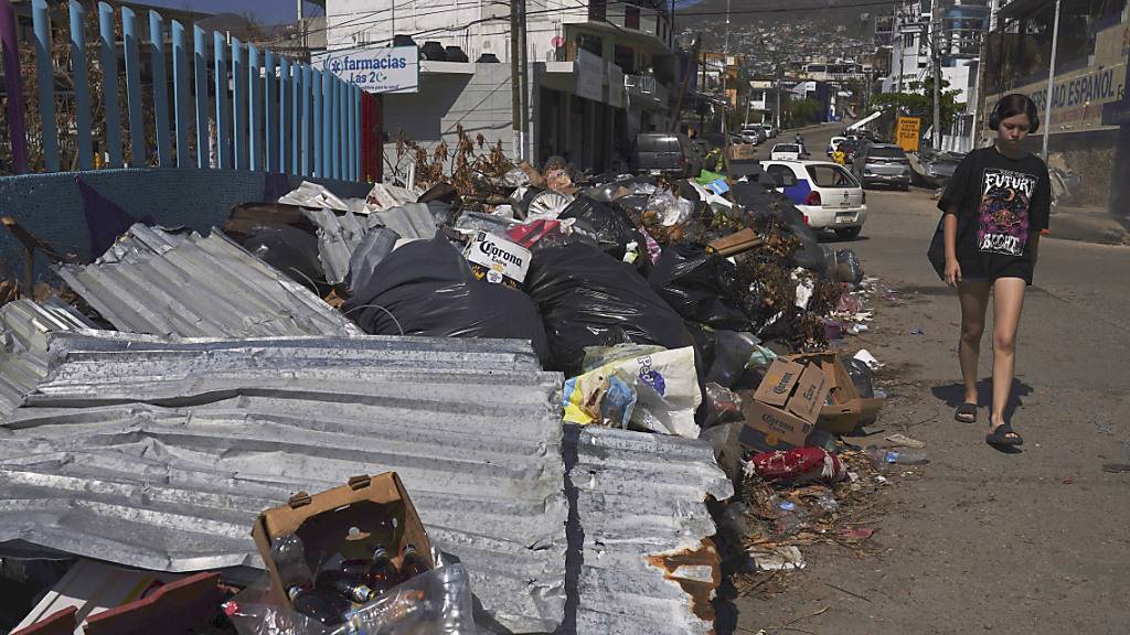 Eine Anwohnerin geht an den Trümmern vorbei, die der Hurrikan «Otis» verursacht hat. «Otis» traf Acapulco am 25. Oktober. Foto: Marco Ugarte/AP/dpa