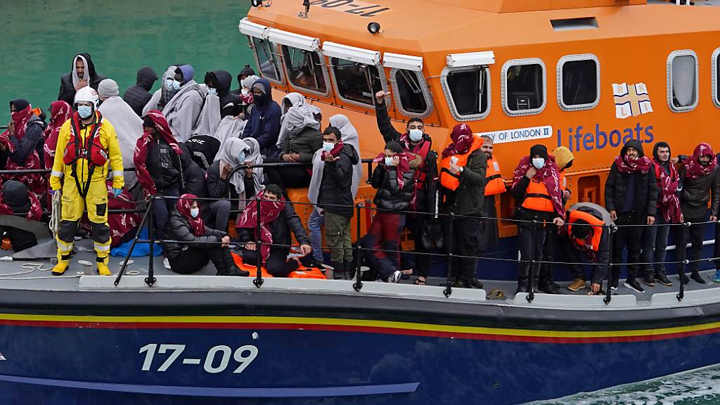 Eine Gruppe von mutmaßlichen Migranten wird an Bord des Dover-Rettungsboots nach Dover in Kent gebracht. Eine Rekordzahl von 1185 Migranten an einem Tag hat am Donnerstag illegal den Ärmelkanal von Frankreich nach Großbritannien überquert. Das teilte das Innenministerium in London am Freitag mit. Foto: Gareth Fuller/PA Wire/dpa